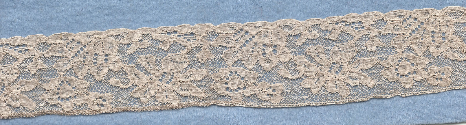 Flowery machine lace with gimp on one side