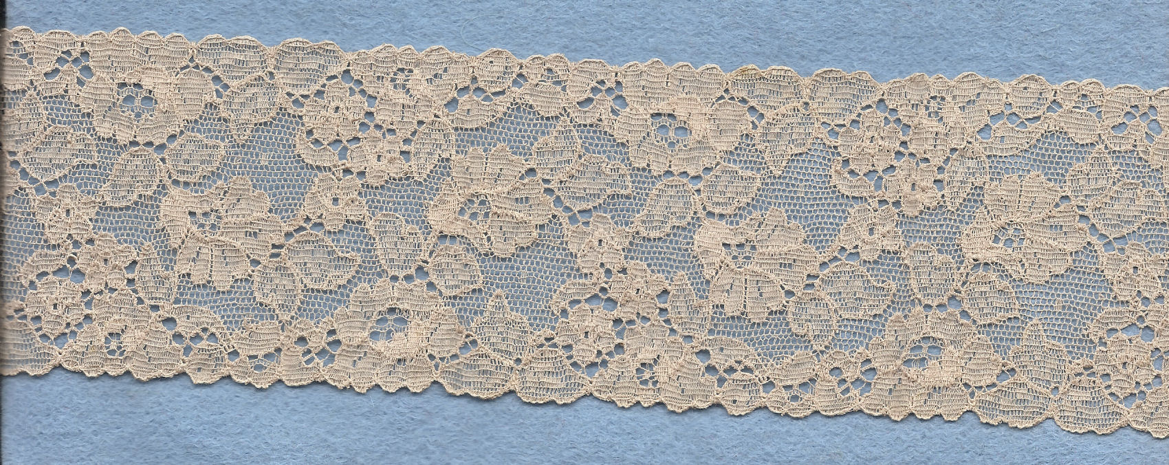 Flowery machine lace with gimp on one side