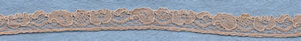 Flowery machine lace with gimp on one side